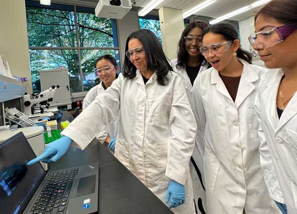 students and professor delgado in lab