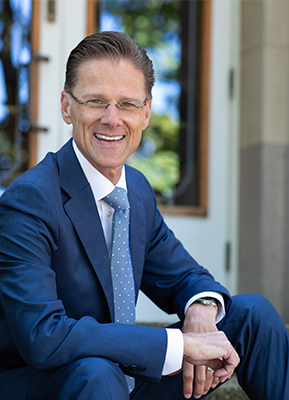 Seattle Pacific University's 10th president Daniel J. Martin sitting on the steps of McKinley Hall.