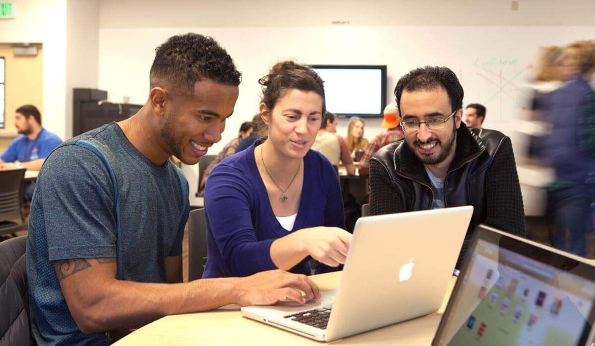 Students and professor looking at laptop