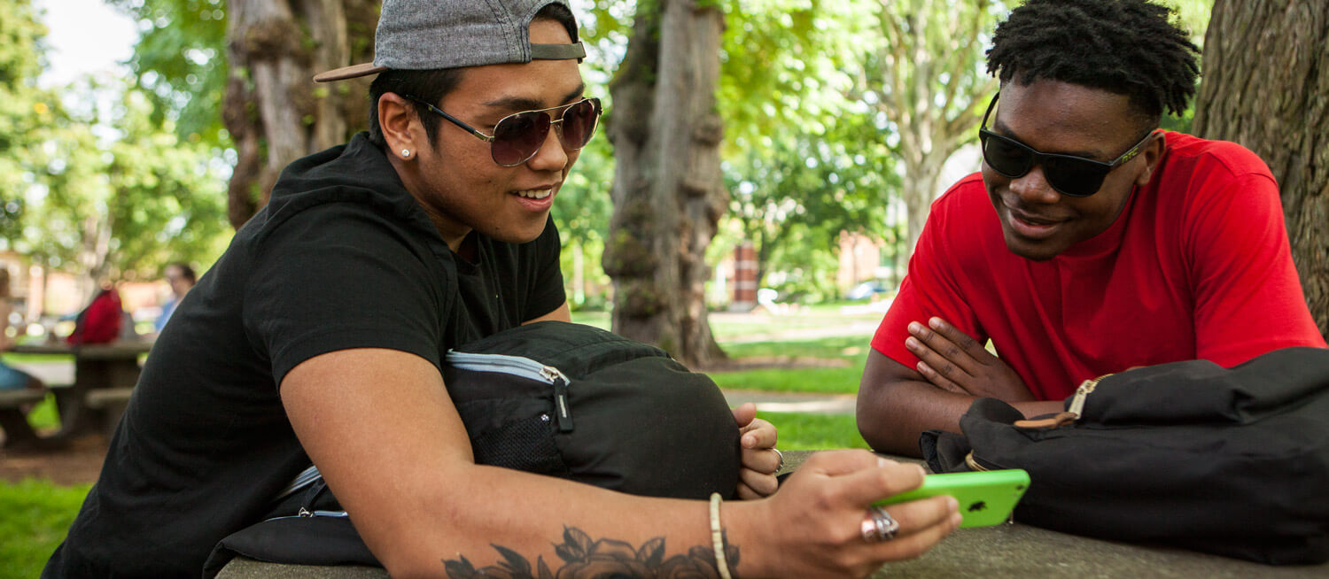 Two students watch a video together.