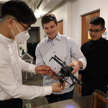 Engineering students examine a drone