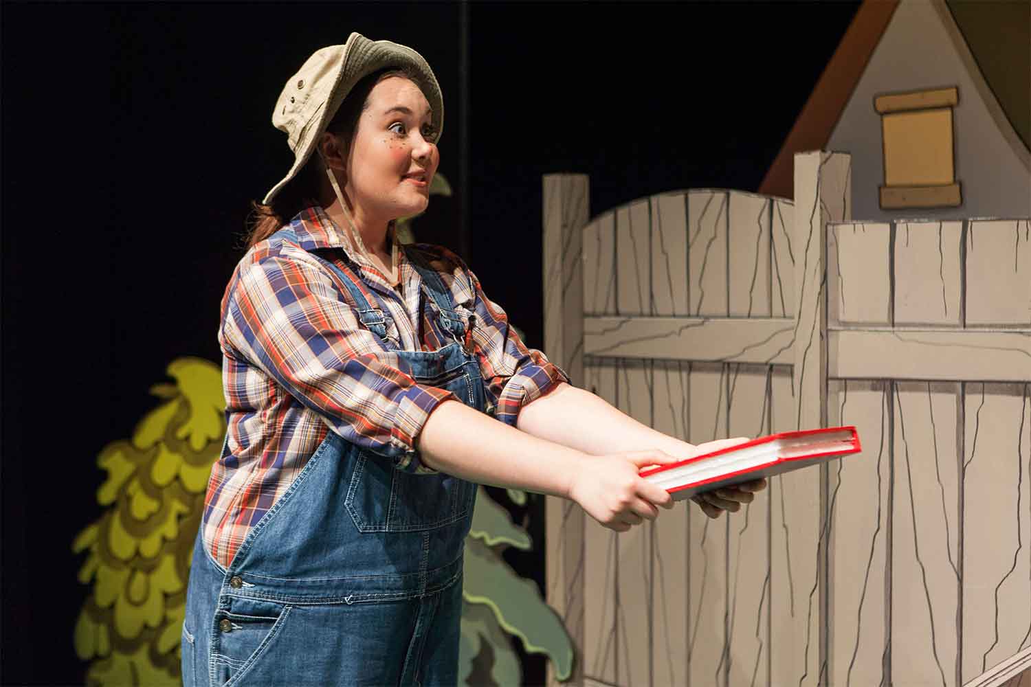 actress in overalls holding a book 