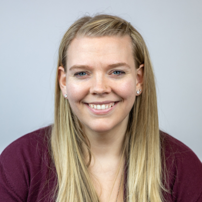 headshot of jenn brown long blonde hair wearing a maroon sweater