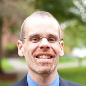 headshot of dave denton wearing glasses and blue shirt and sports coat