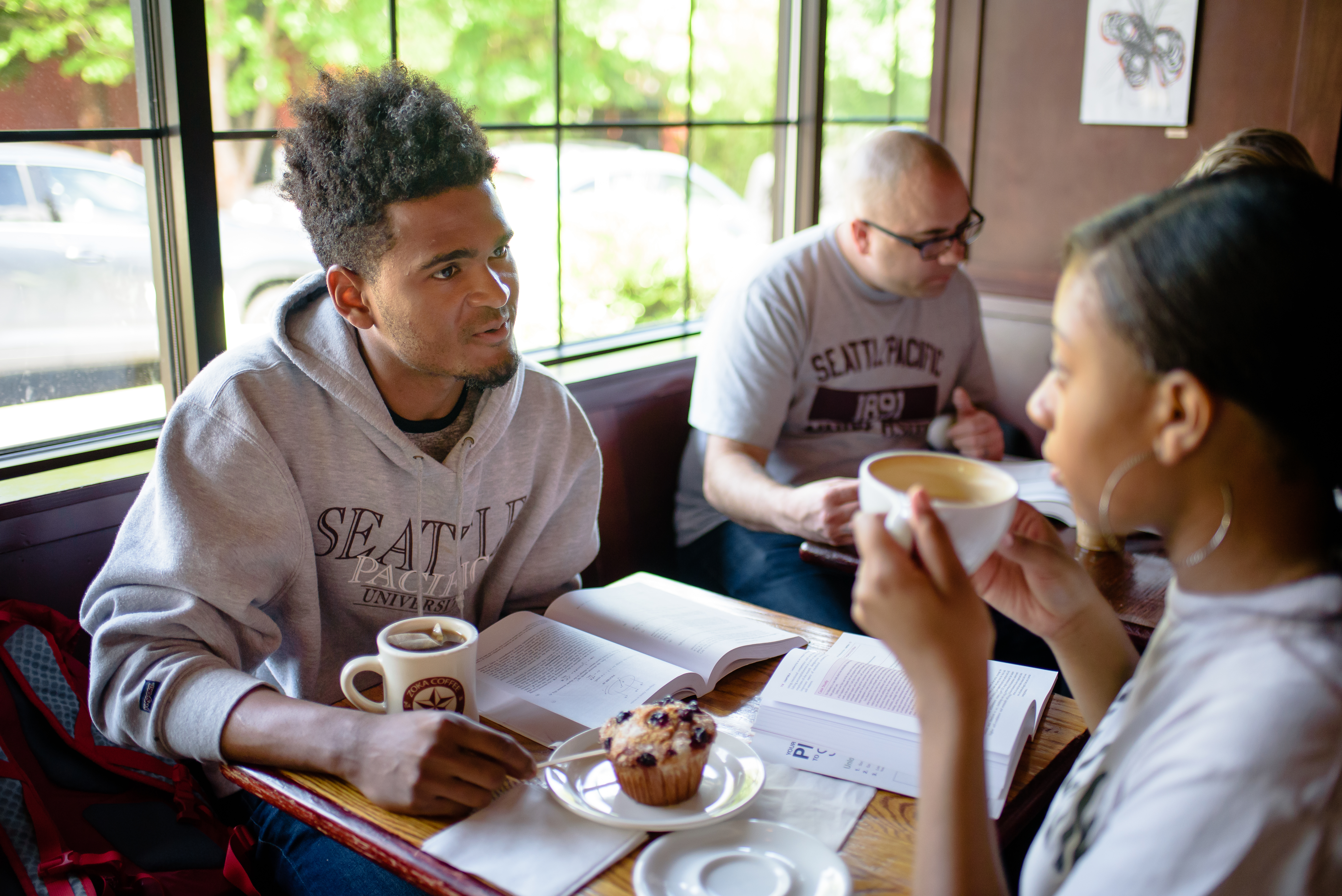 Two students talking at a cafe table