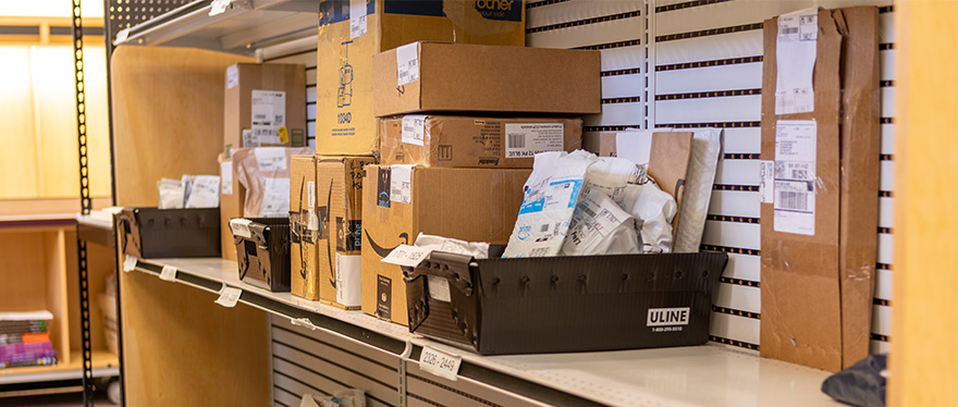 an SPU Mailing Services employee pushes the mail cart through Tiffany Loop