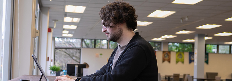 An SPU student works on their laptop in the Lower Weter Commuter Lounge