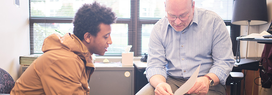 A Student Financial Services employee assists a student with a form | photo by Chris Yang