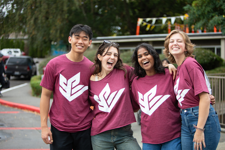 Four SPU student leaders smile broadly over an Orientation weekend