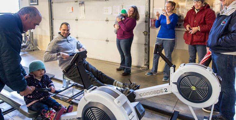 Crew Alumni and families using rowing machines