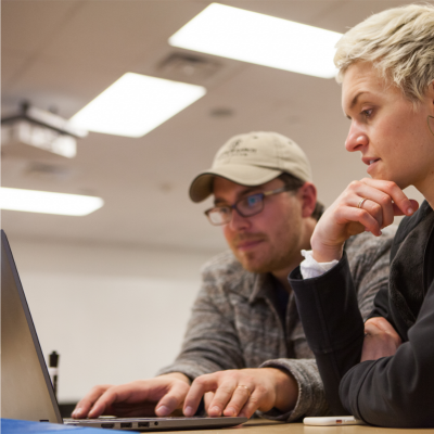 male and female looking at a computer screen