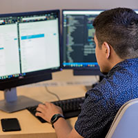 A student worker works at a computer