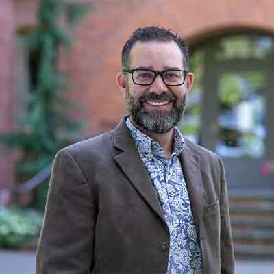 Dean of the School of Theology and Seattle Pacific Seminary Brian Lugioyo stands in from of Alexander and Adelaide Hall