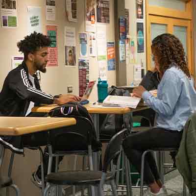 Two students studying together in at a table in the Student Union Building.