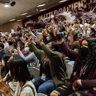 A crowd of students and parents in Royal Brougham Pavilion, cheering on the Falcons.