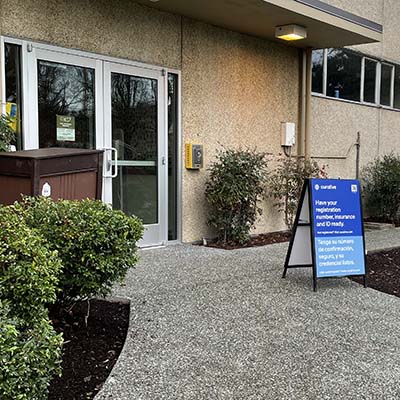 An entrance to the Student Union Building with a sign for COVID-19 testing.