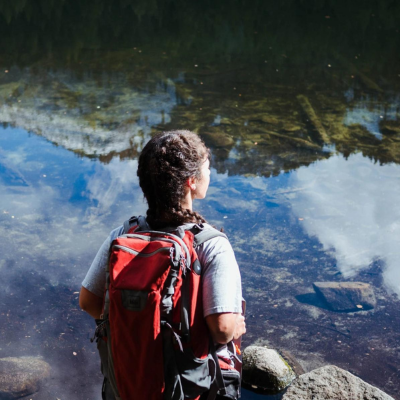 student with backpack looking out over pond