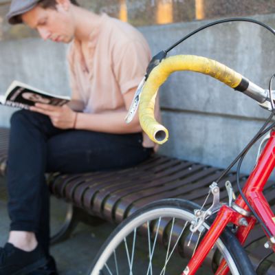 An SPU student reading a book near his bike in Martin Square