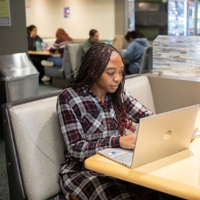 An SPU student sits at her laptop while in the Student Union Building