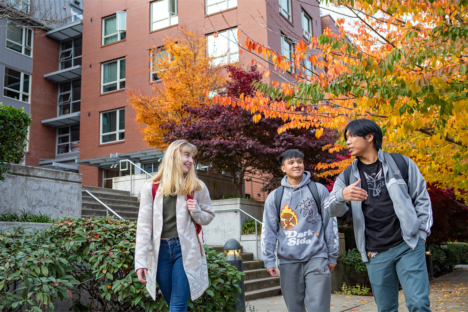 Three SPU students walking on the Seattle Pacific campus during the fall.