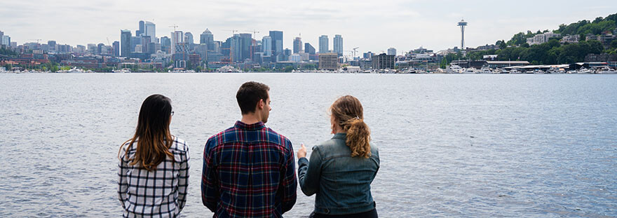 Three SPU students look out across Lake Union towards the Seattle skyline