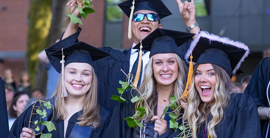 Happy and excited students in their caps and gowns after receiving their ivy at SPU